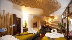 Une salle de spa équipée de deux lits, d’une table de massage et d’un comptoir d’accueil.