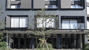 A modern multi-story building with large windows and balconies. - CREW Hotel (Chiang Mai)