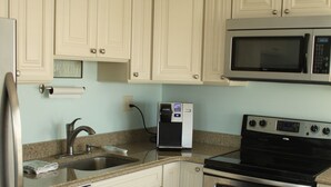 A kitchen with white cabinets, stainless steel appliances, a microwave, an oven, and a dishwasher.