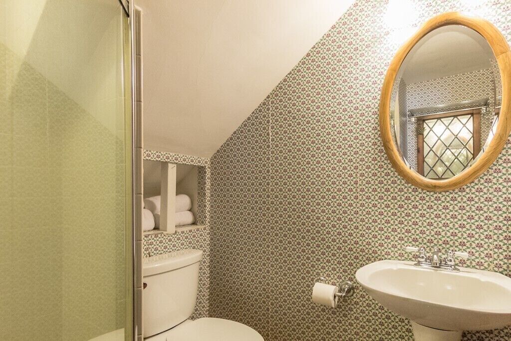A bathroom with a toilet, sink, and shower.