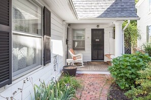 A house with a brick pathway leading to a porch with two white wicker chairs. - Charming downtown home in the center of Historic Marblehead: 5min walk to harbor (Marblehead)