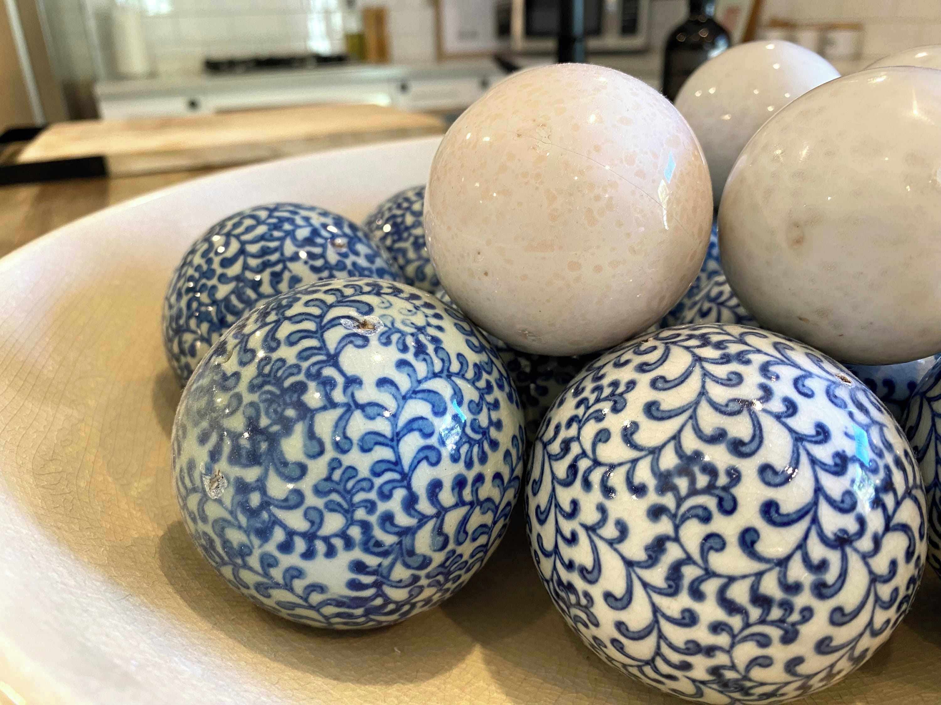 Uma tigela com ovos de cerâmica decorativos.