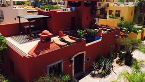 Un edificio de varios pisos con zonas de estar al aire libre, una escalera y una vista de una montaña al fondo.