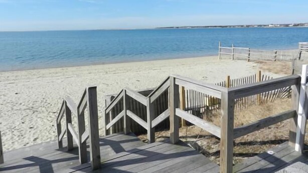 A wooden boardwalk leading to a sandy beach with a clear view of the ocean. - Bright & Airy 3BR Home with Views of Lewis Bay! (1498) (West Yarmouth)