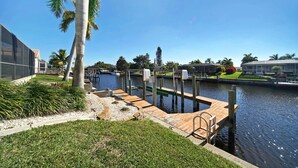A marina with wooden docks, a clear blue sky, and a calm water body.