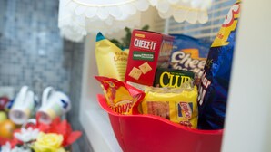 A red basket filled with various snacks and a box of Cheez-It crackers.