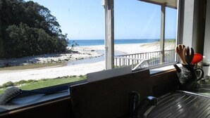 A kitchen with a view of a beach. - Simply the best! Beach front, uninterrupted great views from all rooms (Whiritoa)