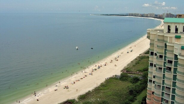 A beach with a high-rise building adjacent to it. - Waterfront Vacation home, Private Pool, Lanai, Dock, Walk to Beach (Marco Island)