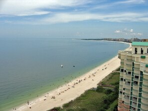 A beach with a high-rise building adjacent to it. - Walk to South Beach! - Heated Pool - Waterfront - Dock/Lift - Direct Access (Marco Island)