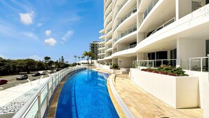 Un hotel moderno con piscina, varios balcones y vistas despejadas del entorno.