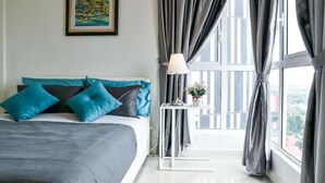 Une chambre à coucher avec un lit, une table de chevet, une lampe et une fenêtre avec des rideaux.