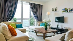 Un salon moderne avec un canapé, une table basse et un téléviseur.