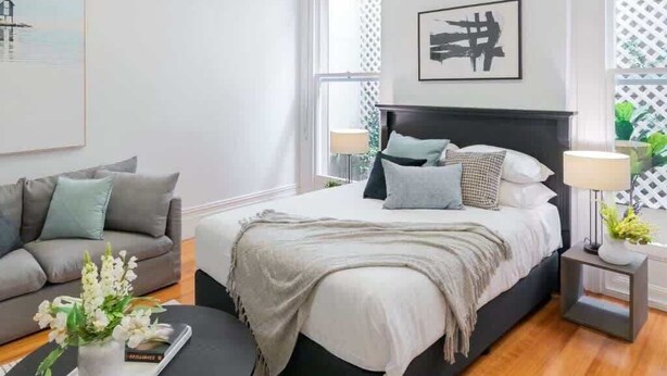 Une chambre à coucher moderne avec un lit, des tables de chevet, un canapé et une table basse.