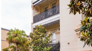 Un bâtiment doté d’un sol à carreaux, d’un escalier avec des rampes décoratives et d’un balcon agrémenté d’une balustrade ornée.
