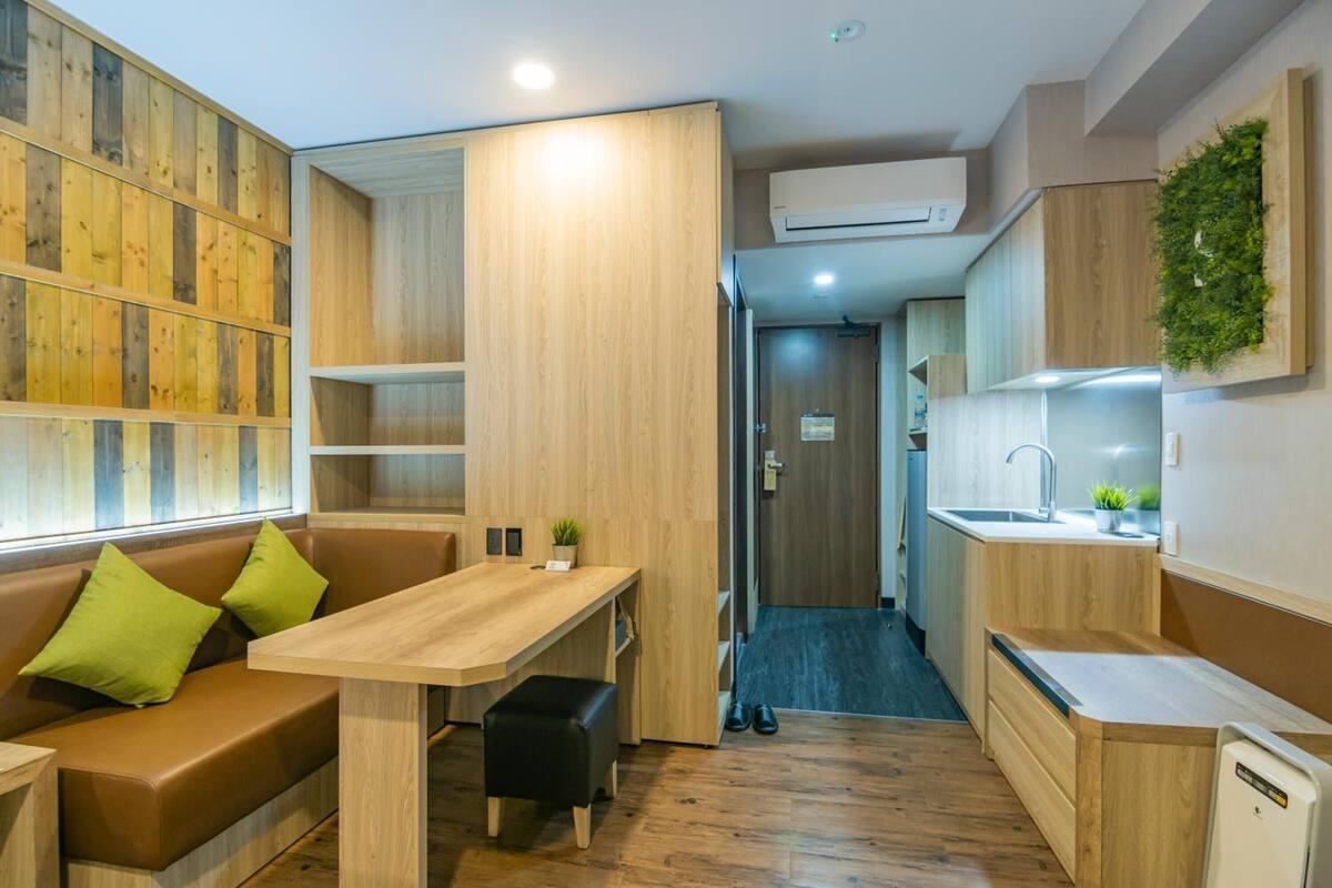 A compact kitchenette with a wooden countertop, a sink, and a small plant.