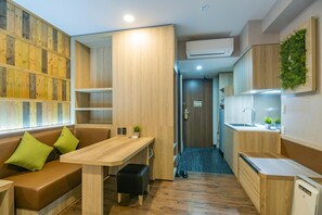 Una kitchenette compacta con encimera de madera, un lavabo y una pequeña planta.