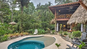 A swimming pool surrounded by tropical vegetation, a wooden deck, and a thatched-roof structure. - Book now!!  Free EGGS!! Also pool, 300m to beach and great gardens! (Playa Chiquita)