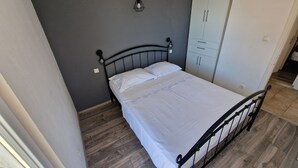 A bedroom with a bed, a wardrobe, and a wall-mounted light fixture. - Apartments Arboreum A2 (5+2) (Ivan Dolac)