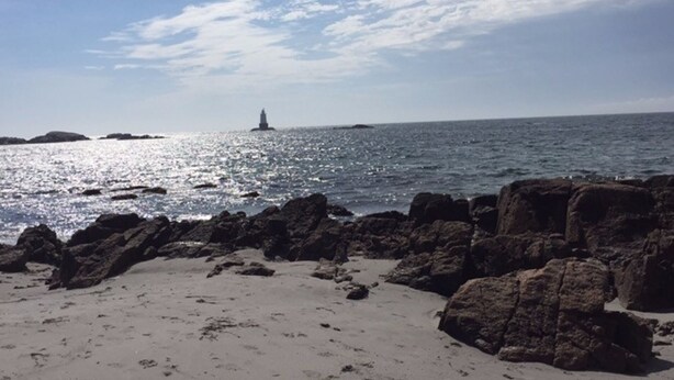 A beach with rocky outcrops and a lighthouse in the distance. - Hope House on Rhode Island's South Shore sits on 6 private acres (Little Compton)