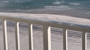 Una playa con vista despejada al océano y un barco a lo lejos.
