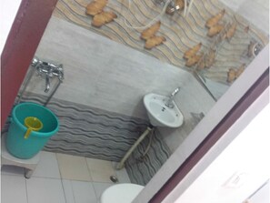 A bathroom with a toilet, sink, and urinal. There is a patterned wall and a tiled floor. - Galaxy Hotel (Lansdowne)