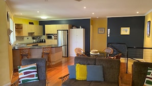 Un espacio habitable compacto con kitchenette, comedor y zona de estar.