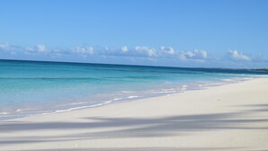 Ein Strand mit klarem türkisblauem Wasser und weißem Sand.