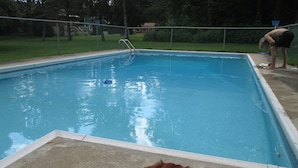 A rectangular swimming pool with a metal ladder leading into it.
