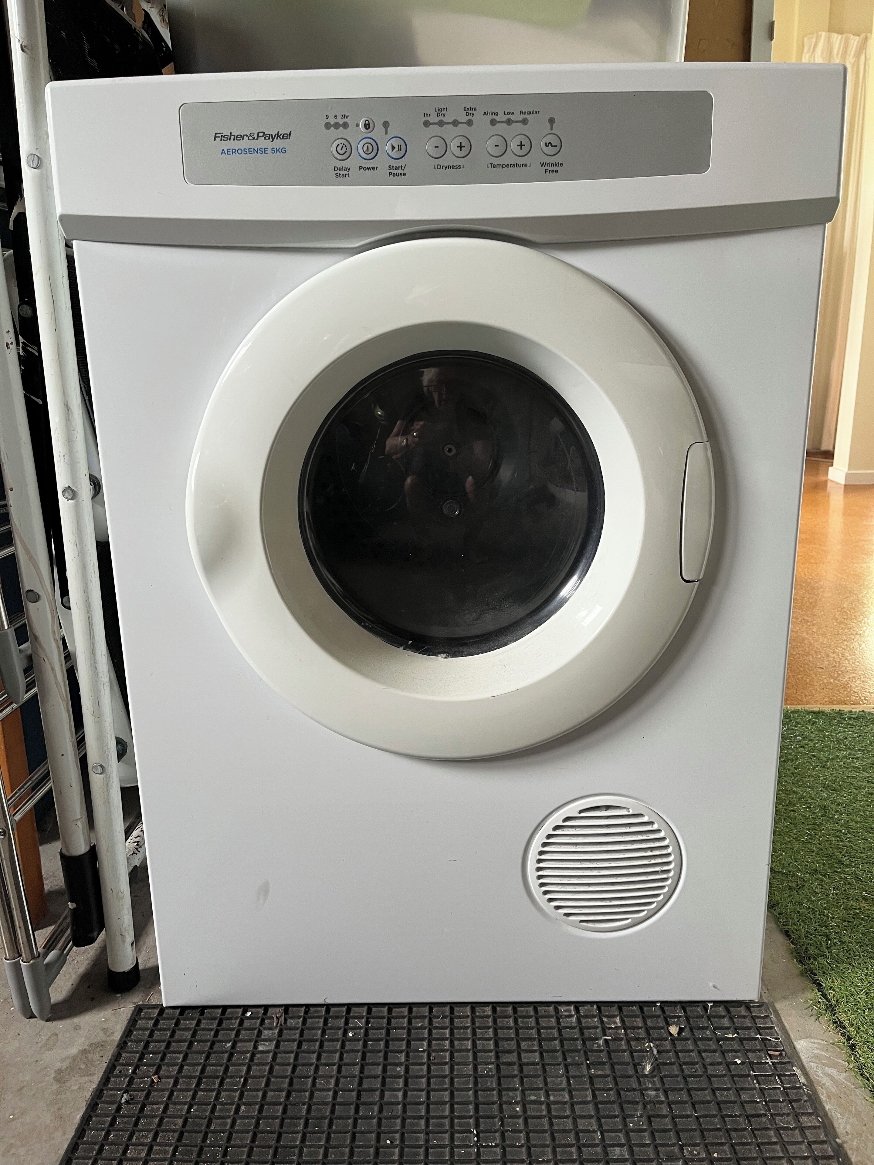 Een witte wasmachine van Fisher & Paykel, met een bedieningspaneel waarop verschillende instellingen zichtbaar zijn.