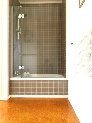 Een bad/douchecombinatie, een haardroger, zeep, shampoo