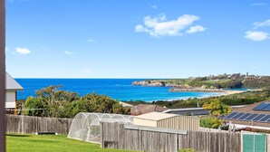 A coastal view with a wooden fence, a greenhouse, and solar panels. - Grandview House - Ocean Views (KIANGA)