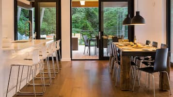 Una cocina moderna con comedor, ventanas amplias y vistas al exterior.