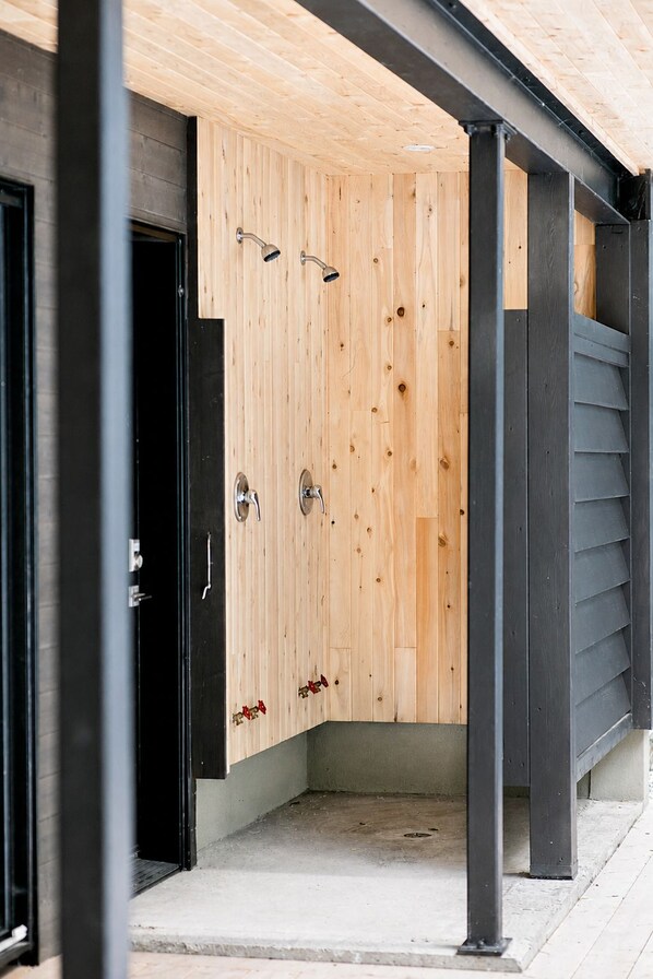 A wooden door with two handles and a metal frame, leading to a concrete floor.