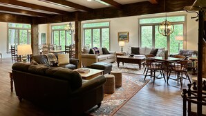A spacious living room with a fireplace, large windows, and a dining area. - Hosting a retreat, family reunion, girls or couples weekend or special occasion? (Ellijay)
