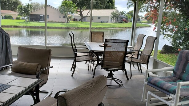 A covered patio with a view of a lake, outdoor furniture, and a grill. - PERFECT RELAXING  GETAWAY FOR COUPLE OR SMALL GROUP (Boynton Beach)