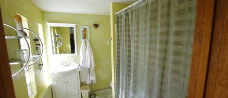 A bathroom with a white sink, mirror, and shower curtain.