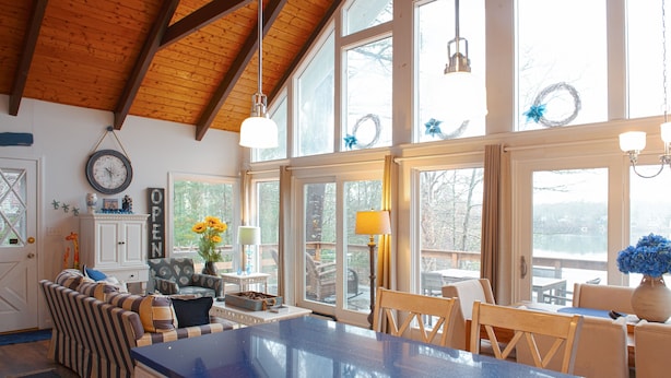 A spacious kitchen with a large island, wooden ceiling beams, and large windows. - Beach Front on Beautiful Jenkins Pond, Quiet Area, 
Discounted off season rates! (East Falmouth)