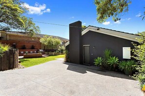 A modern two-story house with a paved driveway leading to a dark-colored garage.