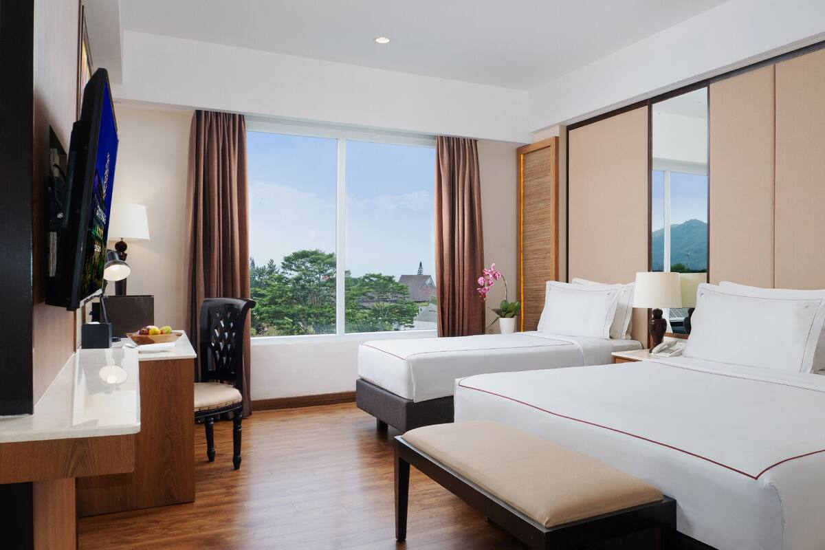 Une chambre d’hôtel avec un grand lit, un bureau, une chaise et un téléviseur.