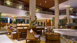 A spacious lobby with a reception desk, seating area, and decorative sculptures. - Grand Sunshine Resort & Convention (Soreang)