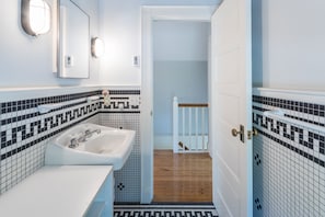 Bathroom features a sink, mirror, and tiled backsplash.