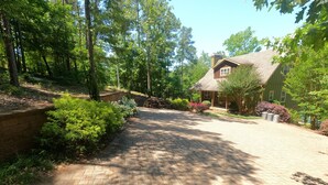 A paved driveway leading to a house surrounded by lush greenery and trees. - Lake Wedowee Privacy (Wedowee)