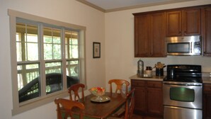 A kitchen with wooden cabinets, a stainless steel oven, and a microwave. - Lake Wedowee Privacy (Wedowee)