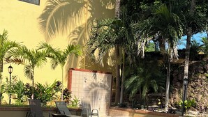 A swimming pool with tiled steps, surrounded by lounge chairs and palm trees. - Summer in Playa Flamingo Costa Rica. 2bd/2bath Sleeps 6 Ocean View,new upgrade (Playa Flamingo)