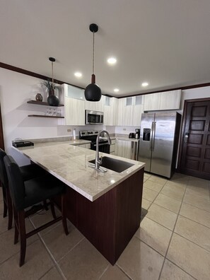 Een koelkast/vriezer, een magnetron, een oven, een kookplaat