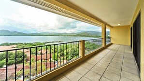 A balcony with a view of a lake and mountains. - Summer in Playa Flamingo Costa Rica. 2bd/2bath Sleeps 6 Ocean View,new upgrade (Playa Flamingo)