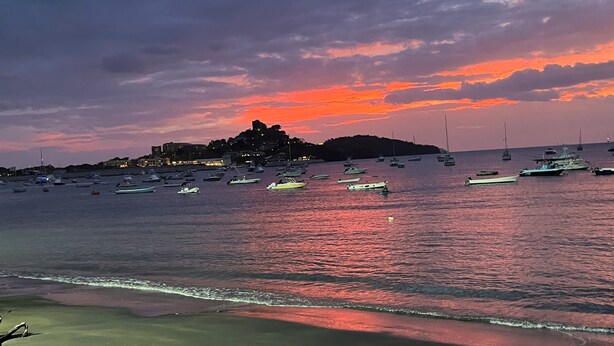 A coastal scene with boats, a beach, and a hill with buildings. - Summer in Playa Flamingo Costa Rica. 2bd/2bath Sleeps 6 Ocean View,new upgrade (Playa Flamingo)