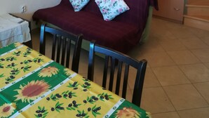 Un coin repas avec une table dressée pour deux personnes, un escalier en bois et une armoire.
