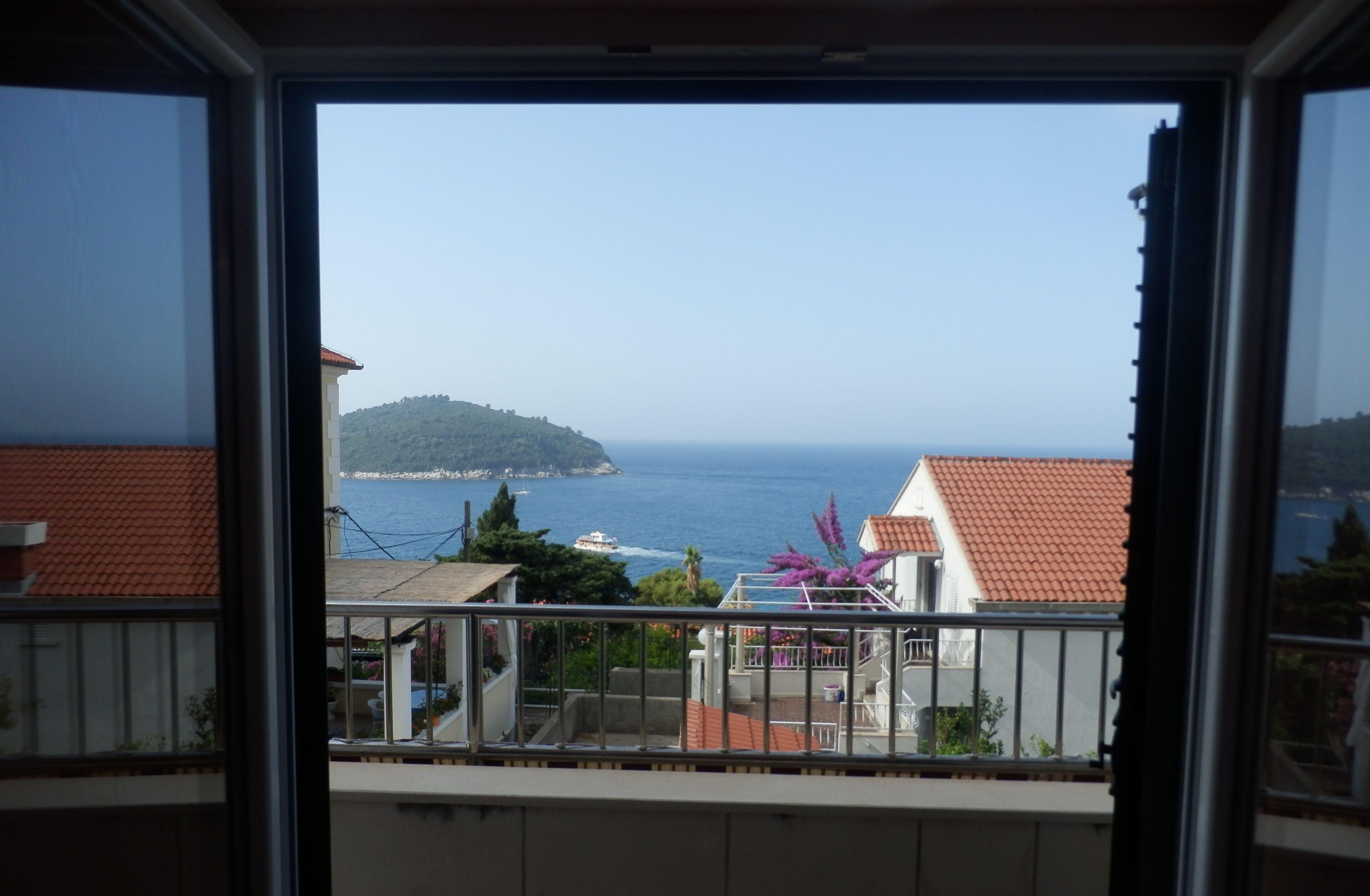 Ein Balkon mit Blick auf das Meer und eine entfernte Insel.