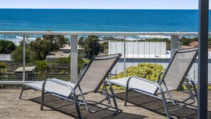 A balcony with two metal chairs facing a view of the ocean. - IL Mare (expansive ocean views)  (Apollo Bay/ Skenes Creek)